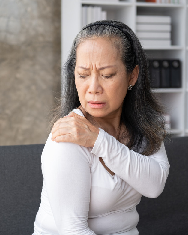 Lady holding her shoulder as she seems to be in pain 