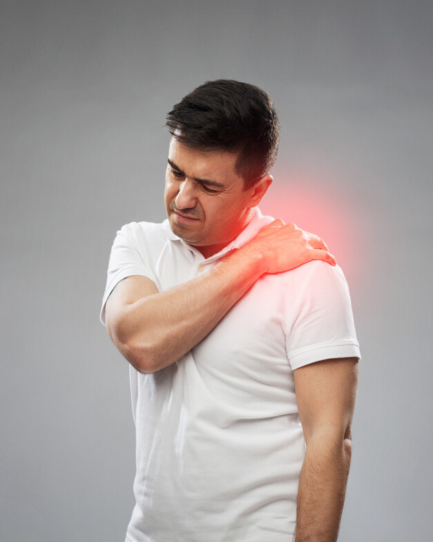 A guy holding his shoulder as he is in pain 