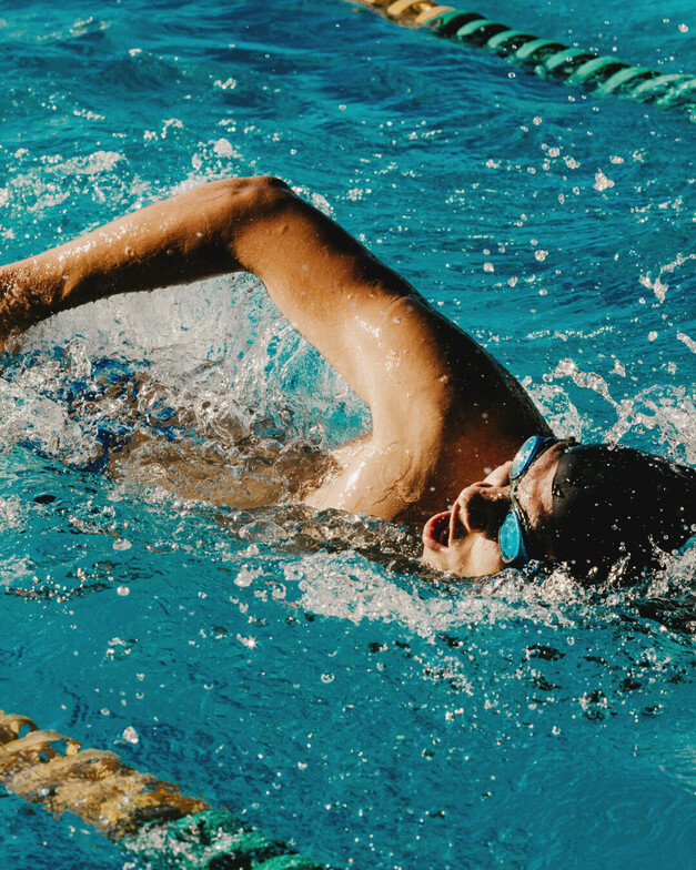 A guy swimming laps in a pool. 