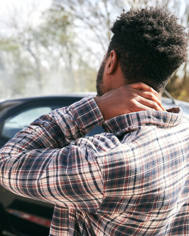 A guy holding his neck from whiplas after a car accident 